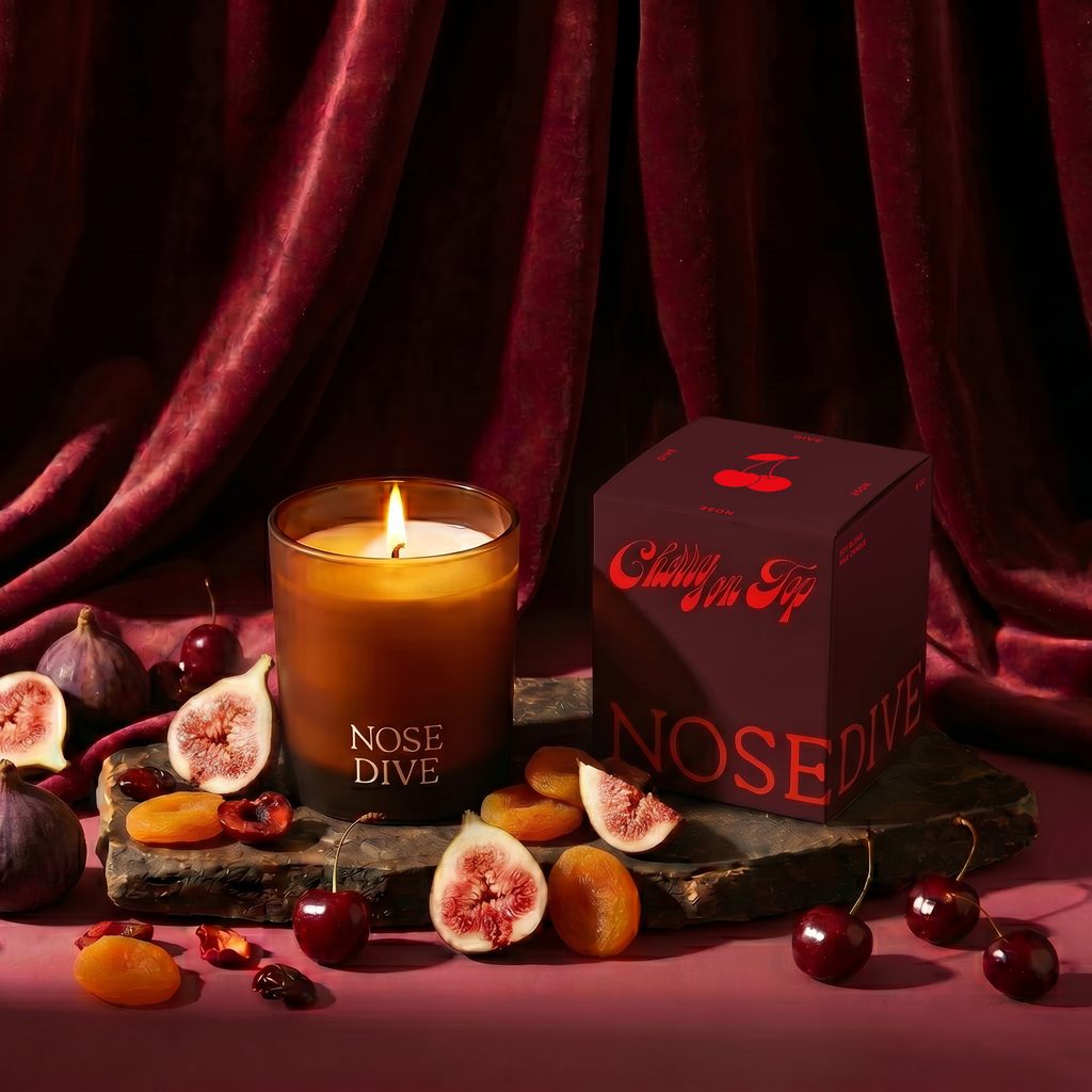 Cherry on Top scented candle by Nose Dive x Brooklyn's Bites on draped fabric background